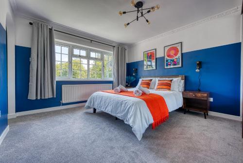 um quarto azul com uma cama e uma janela em Large 4 bedroom house - driveway - close to NEC! em Solihull