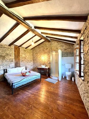 a bedroom with a bed in a stone room at Tuscany Escape in Borgo a Mozzano