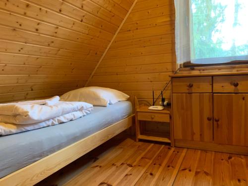 a bedroom with a bed in a wooden cabin at Domki pod Kiczerą w Baligrodzie, Bieszczady in Baligród