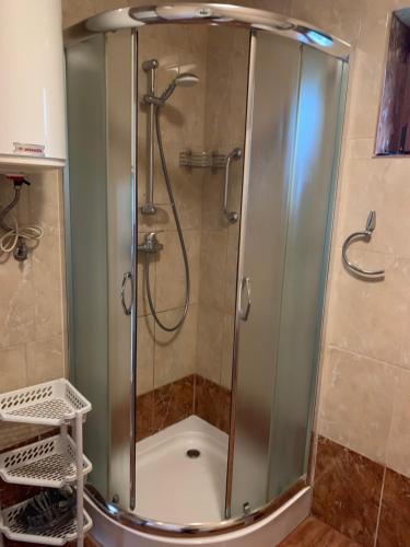a shower with a glass door in a bathroom at Domki pod Kiczerą w Baligrodzie, Bieszczady in Baligród