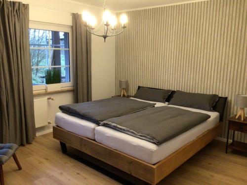 a bedroom with a large bed with a window at Ferienwohnung am Steinsbach in Bad Berleburg