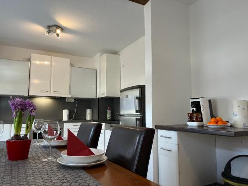a kitchen with a table and chairs with wine glasses at Beishan Appartements Nürnberg in Nürnberg