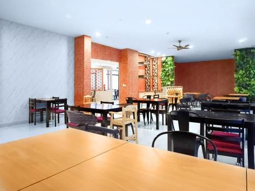 Phoenix Hotel Karon Beach في شاطئ كارون: غرفة طعام مع طاولات وكراسي في مطعم