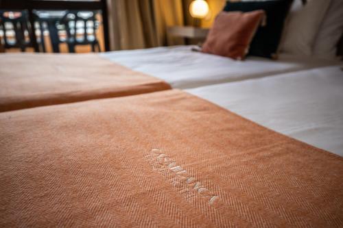 a close up of two beds in a hotel room at Casablanca Unique Hotel in Monte Gordo