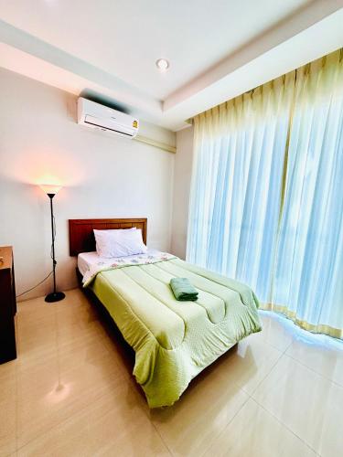 1 dormitorio con cama y ventana grande en S303 Good Apartment Chalong Na-kok, en Phuket