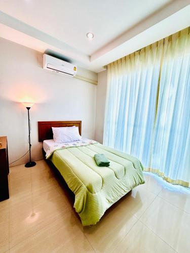 a bedroom with a bed and a large window at S303 Good Apartment Chalong Na-kok in Phuket Town
