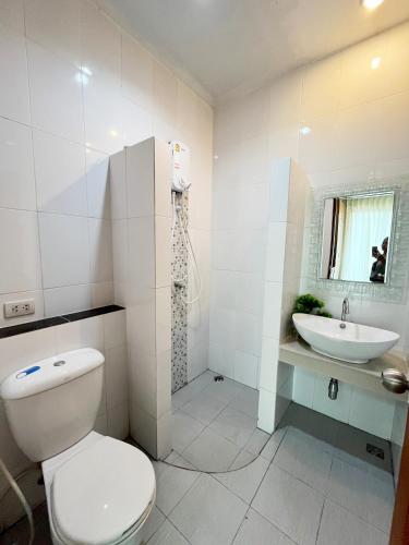 Baño blanco con aseo y lavamanos en S303 Good Apartment Chalong Na-kok, en Phuket