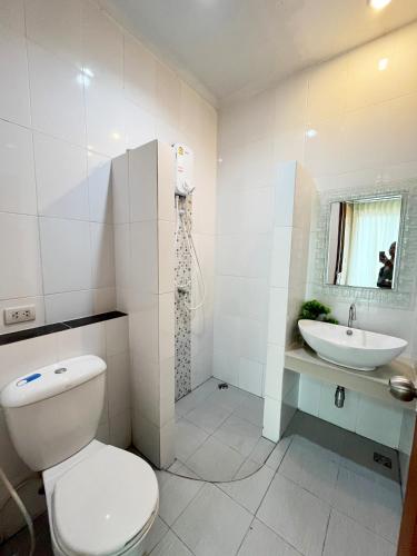 a white bathroom with a toilet and a sink at S303 Good Apartment Chalong Na-kok in Phuket Town
