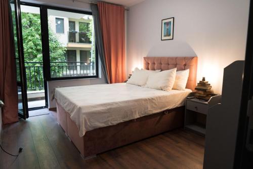 1 dormitorio con cama y ventana grande en Апартамент за настаняване Октавия, Octavia House, en Plovdiv
