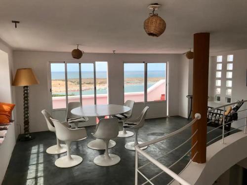 a dining room with a table and chairs and a view of the beach at Dar Dielna in Oualidia