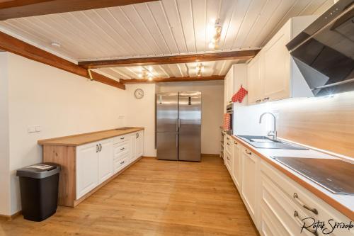 a large kitchen with a stainless steel refrigerator at Roubenka Výletní in Desná