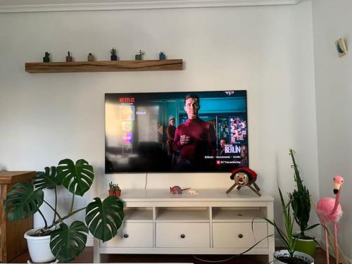 a flat screen tv sitting on top of a white entertainment center at Apartamento en Liencres in Liencres