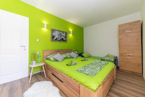 ein grünes Schlafzimmer mit einem großen Bett und einer grünen Wand in der Unterkunft Villa Tamara in Biograd na Moru