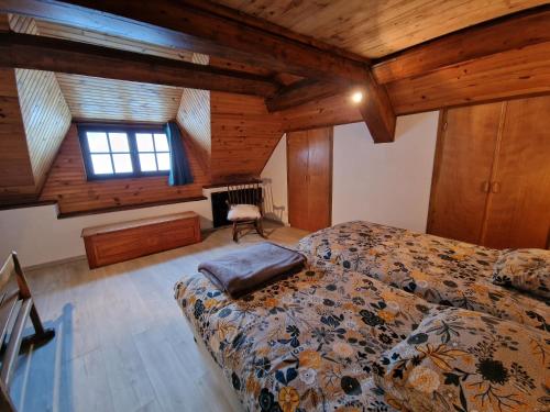 a bedroom with a bed in a room with wooden ceilings at LES BOUVREUILS in Les Deux Alpes