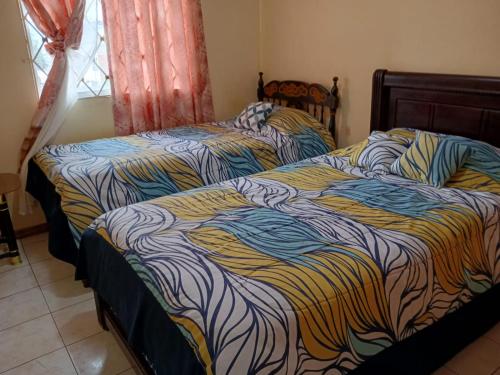 two beds sitting next to each other in a bedroom at Acogedor departamento in Loja