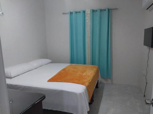 - une chambre avec un lit et des rideaux bleus dans l'établissement Debs Cozy Cove, à Discovery Bay
