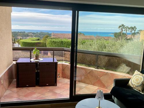 a room with a balcony with a view of the ocean at Appartement Sanary vue mer au calme in Sanary-sur-Mer
