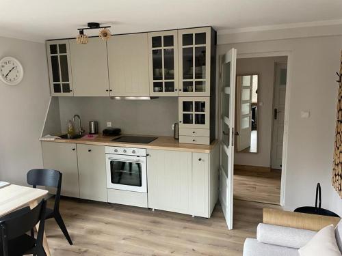 a kitchen with white cabinets and a table in a room at Willa Kora in Szczyrk