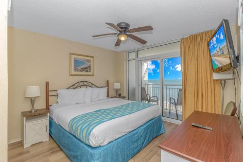 1 dormitorio con 1 cama, ventilador de techo y ventana en Atlantica 757, en Myrtle Beach