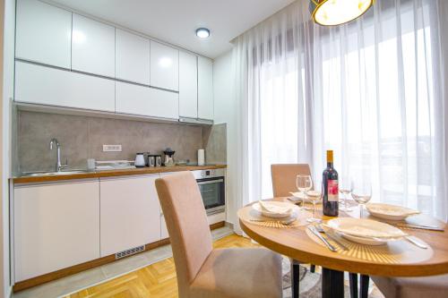 a kitchen with a wooden table with wine glasses at Apartman Holiday Binis Spa in Zlatibor