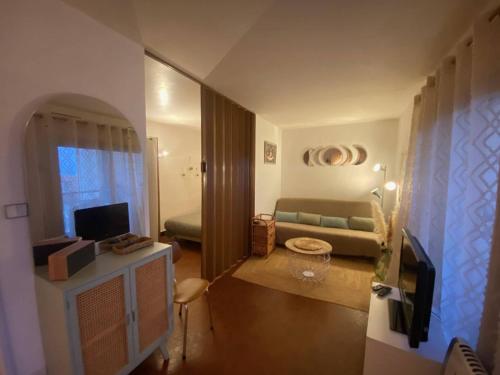 un salon avec un canapé et une télévision dans l'établissement Apt 4 pers - Proche plage, parking privé, TV, lave-linge - FR-1-81-605, au Barcarès