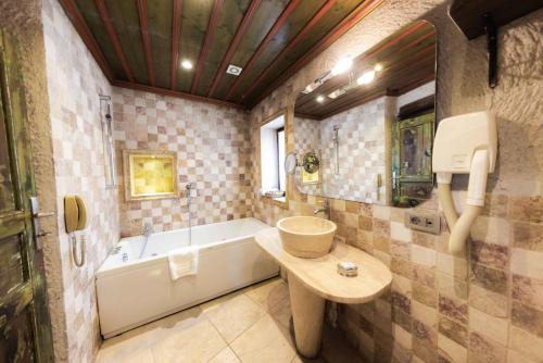 a bathroom with a sink and a bath tub at Cappadocia Cave Suites in Goreme