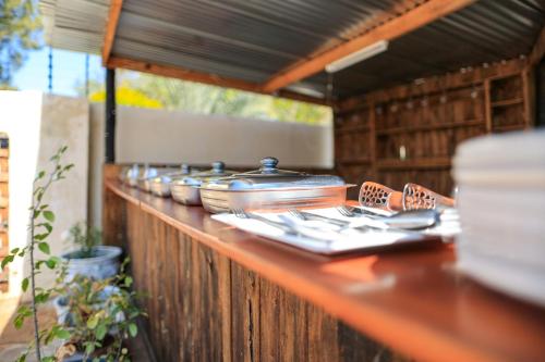 a wooden counter with plates and utensils on it at Green Lagoon Guest House Tawana in Gaborone