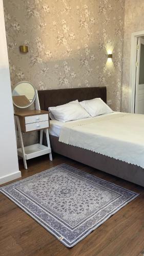 1 dormitorio con cama y mesa con espejo en Квартира посуточно Алматы en Almaty