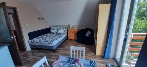 Habitación pequeña con cama y mesa en Bodzavirág Apartman, en Balatonvilágos