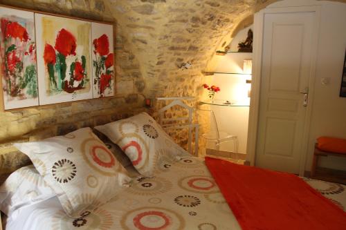 - une chambre avec un lit dans une pièce dotée d'un mur en pierre dans l'établissement Chambre Cévennole, à Saint-Jean-de-Ceyrargues