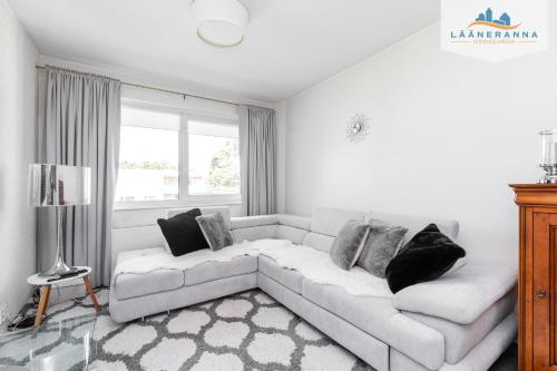 sala de estar blanca con sofá y ventana en Romantiline Haapsalu ootab Sind en Haapsalu