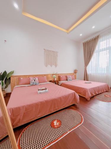 a bedroom with two beds with red sheets at LaLa Villa Hue in Hue