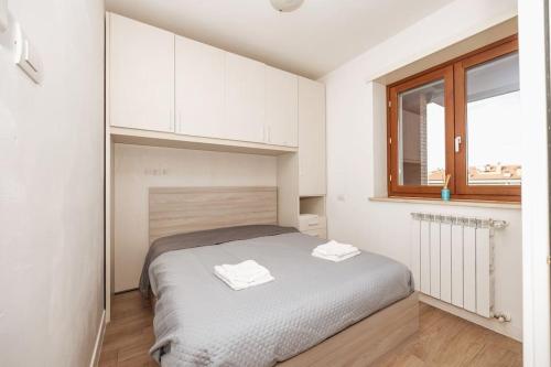 a bedroom with a bed with white cabinets and a window at Jacuzzi Panoramica a Roma, Netflix e Comfort in Rome