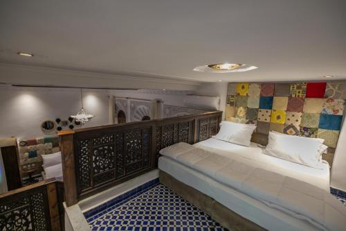 1 dormitorio con 1 cama grande y cabecero de madera en Darif's Riad & Spa en Fez