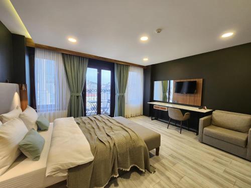 a bedroom with a bed and a desk and a television at Taksim Landhouse in Istanbul