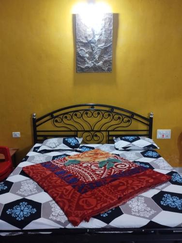 a bedroom with a bed with a quilt on it at Laxmi Cottage in Matheran
