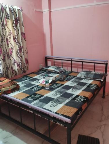 a bed in a room with a table at Laxmi Cottage in Matheran