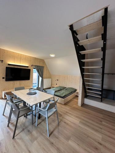 a room with a table and chairs and a bed at Penzion a Restaurace Pod Sjezdovkou in Čenkovice