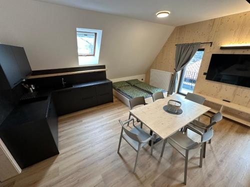 a room with a table and chairs and a kitchen at Penzion a Restaurace Pod Sjezdovkou in Čenkovice
