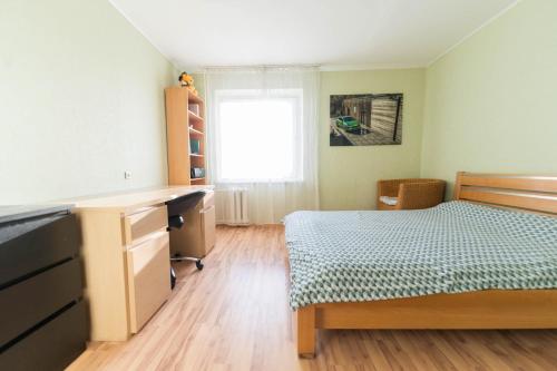 a bedroom with a bed and a desk and a window at Šeškinės 61 Spacious Cozy Apartment in Vilnius