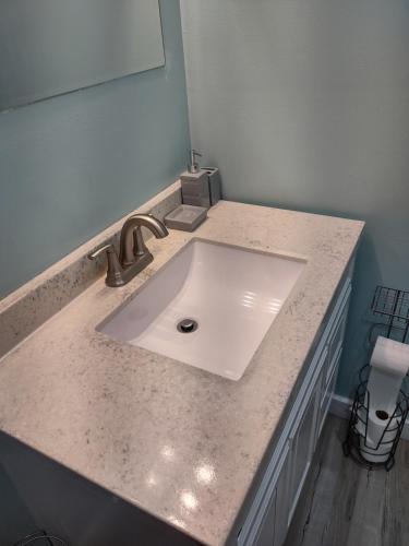 W łazience znajduje się umywalka i lustro. w obiekcie Unique Center Of Downtown Elmira w mieście Elmira