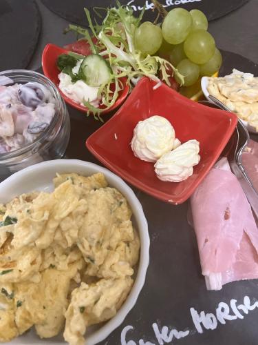a table topped with a plate of food and grapes at Das BilderbuchCafe - Ferien Apartment NO 5 - Markt 7 in Havelberg