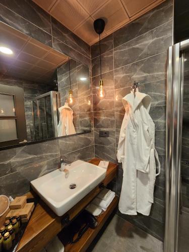 a bathroom with a sink and a white robe at Taksim Landhouse Hotel 1 Min to Taksim Square in Istanbul