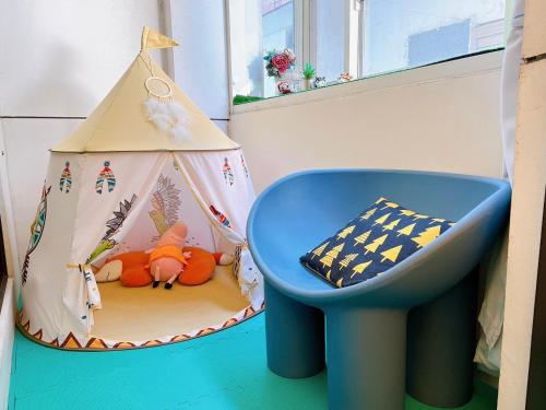 a childs room with a toy tent and a blue chair at 羅東遇巧寓手作早餐可使用國旅卡有代辦泛舟賞鯨獨木舟等活動 in Luodong