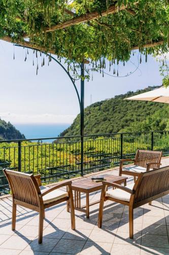 a patio with two chairs and a table and an umbrella at Villa San Lorenzo in Scala