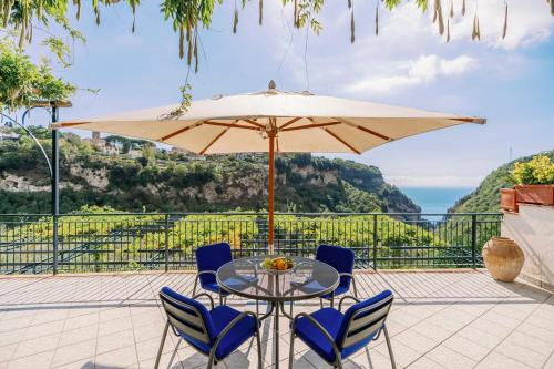 a patio with a table and chairs and an umbrella at Villa San Lorenzo in Scala