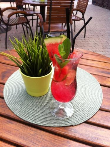 a drink in a vase on a table with a plant at Piwnica Rycerska Kęty in Kęty
