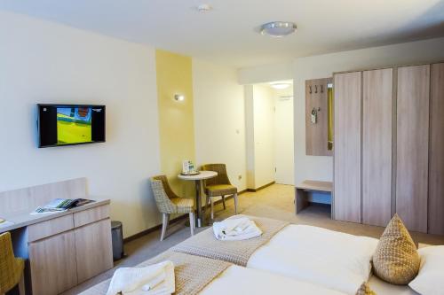 a hotel room with two beds and a table at Hotel Willa Odkrywców in Szklarska Poręba