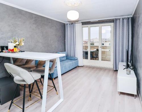 un soggiorno con tavolo bianco e divano blu di Appartement moderne, proche du Parc de la tête d'Or et de Lyon a Villeurbanne