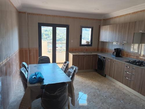 a kitchen with a table and chairs in a room at Bel Horizon mosta in Mostaganem